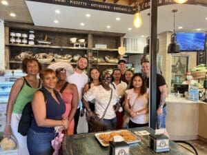 A group of people standing around a table with food.