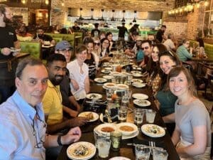 A group of people sitting at a table with plates.