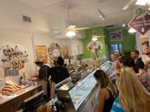 A group of people standing around an ice cream shop.