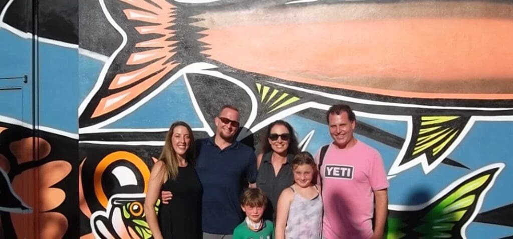 A Family Posing in Front of a Wall With Art