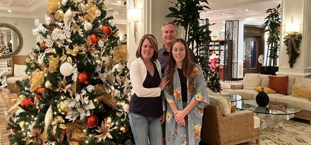 A Man With two Women Beside a Christmas Tree