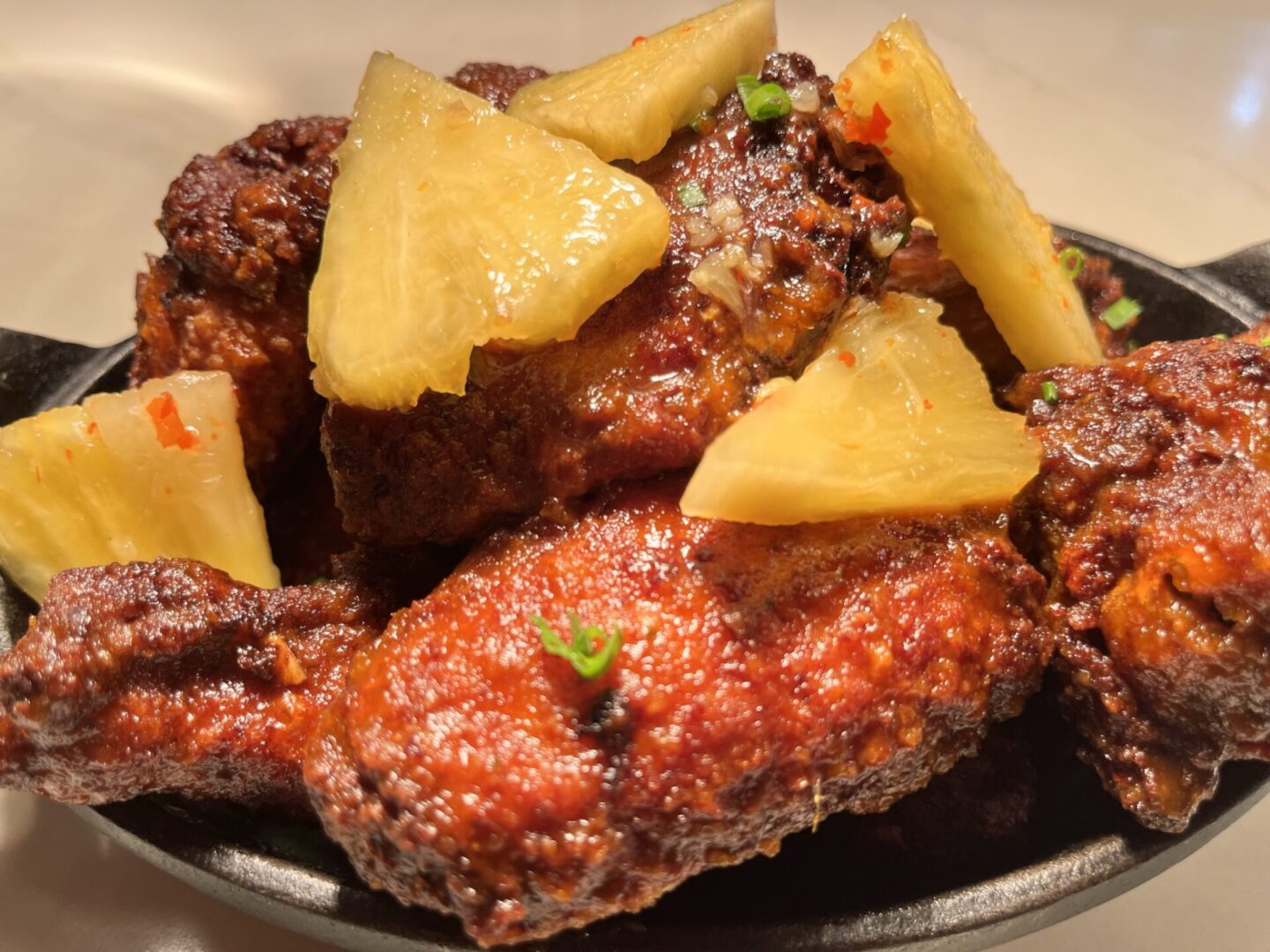 A Fried Chicken on a Plate With Pineapple Slices
