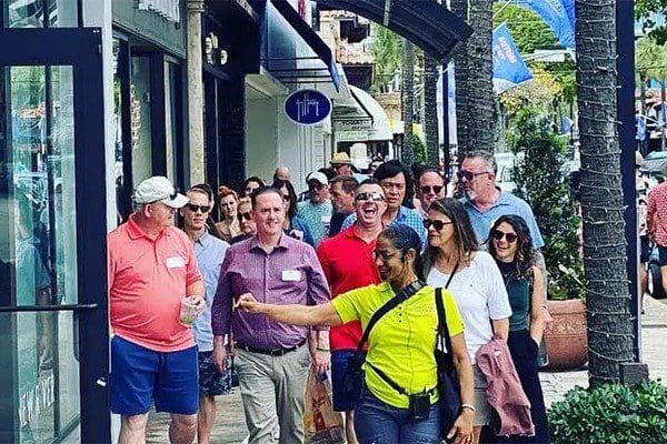 A group of people standing on the sidewalk.