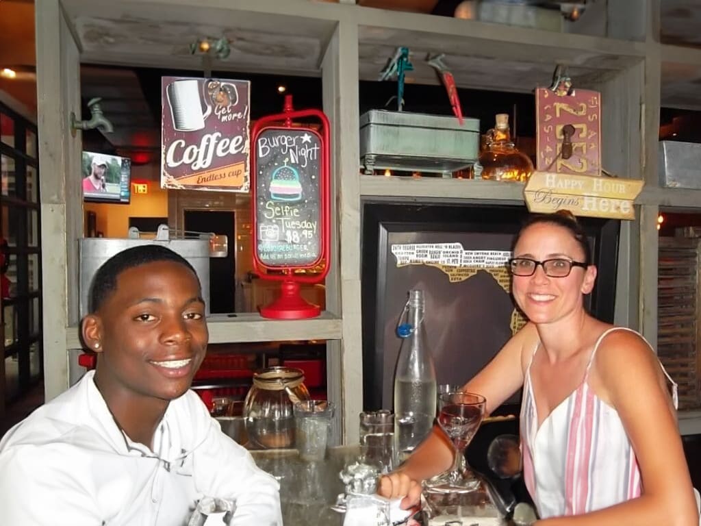 Two people smiling in a restaurant.