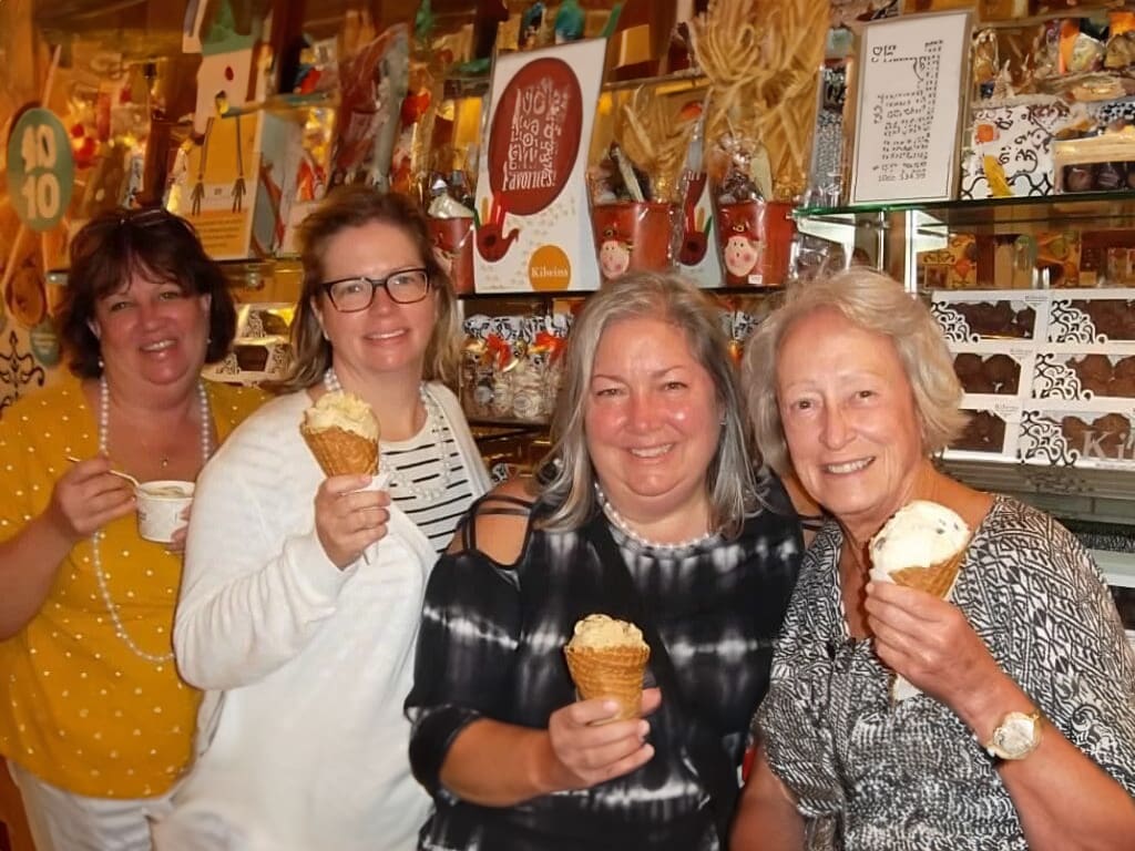 Four women smiling and holding ice cream cones.