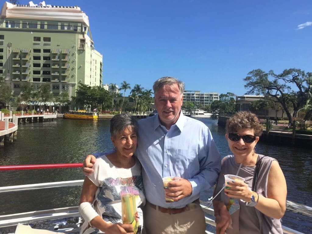 Three people on a boat with drinks.