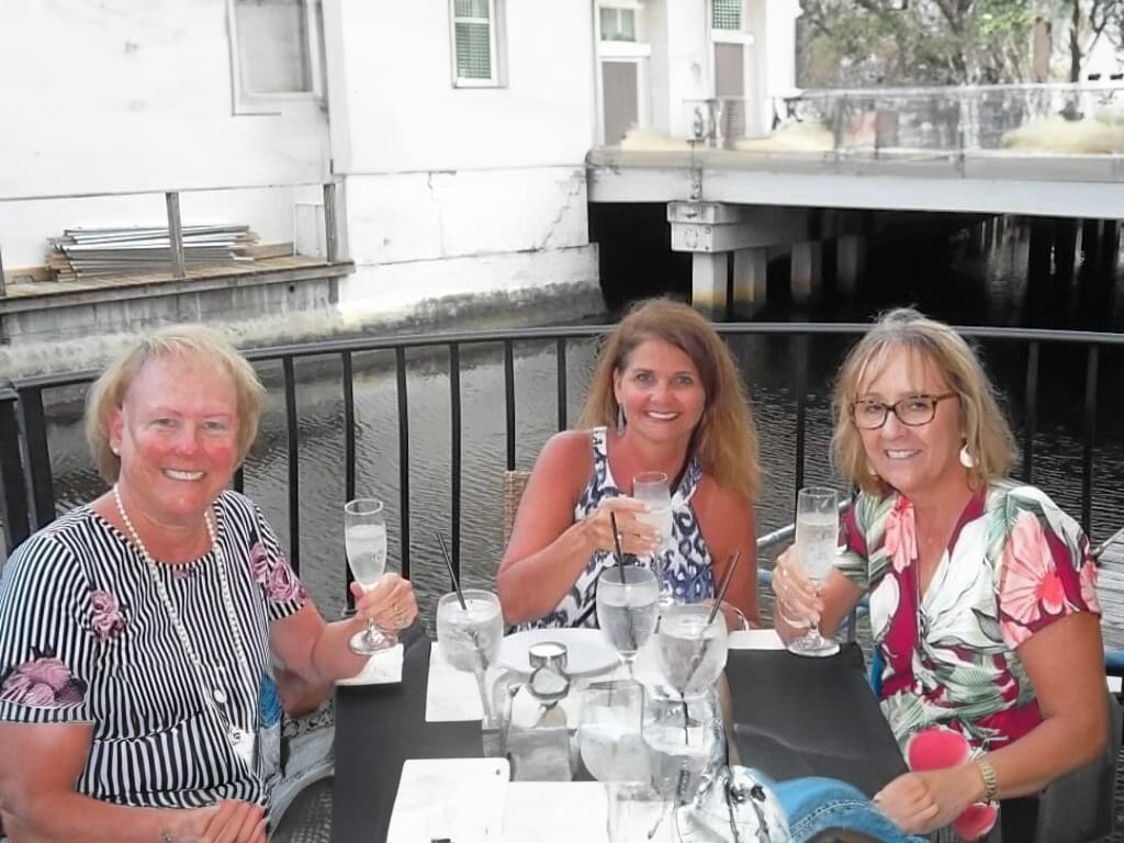 Three women enjoying drinks at a restaurant.