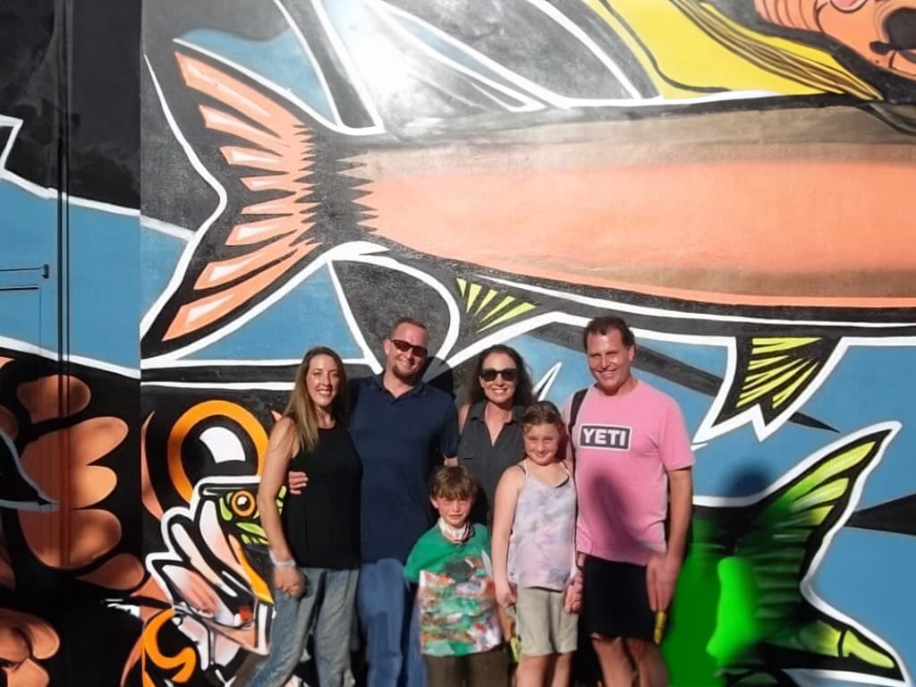 Family portrait in front of a fish mural.