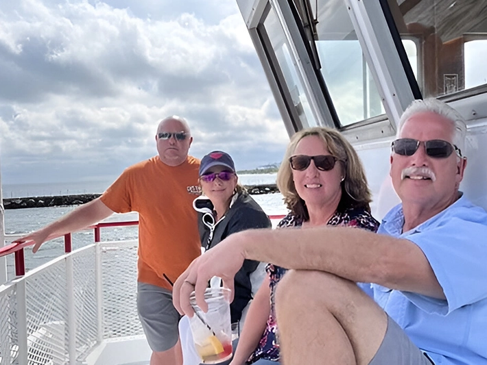 Four people smiling on a boat.